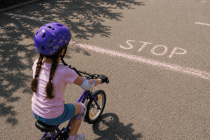 Schnell Fahrradfahren lernen ohne Frust: mit der Schalmethode Kind stoppt an selbst gemalter STOP-Linie
